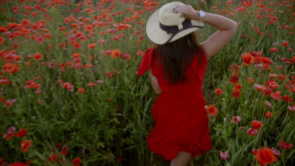 Young Woman Running in a Poppy Field