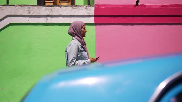 Young woman wearing hijab out and about in the city alt