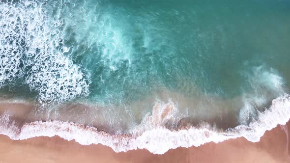 Aerial Top View of Ocean Waves Reaching Beach Shore. Drone Footage. alt