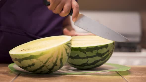 Slicing half a yellow watermelon into quarters, CLOSE UP alt