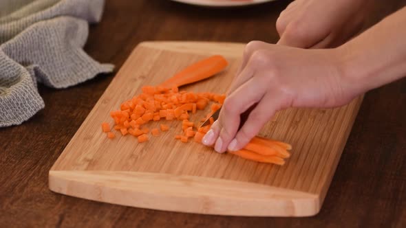 Female Chef Chopping Carrots on a Wooden Board