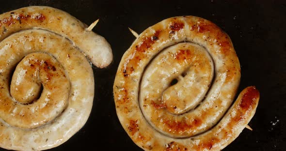 Fragrant Sausage Is Fried in a Frying Pan with Hot Steam.  alt