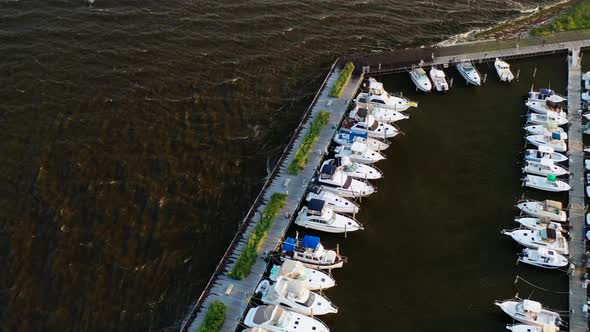 tilt down pan over the boats on the pier at East Islip Marina & Park at sunset on a very windy eveni alt