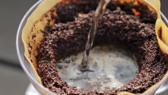 Pouring hot water into coffee filter with slow motion alt