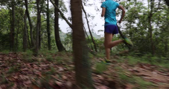 Woman runner running on forest trail, slow motion alt