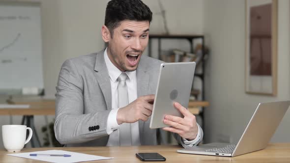 Businessman Celebrating Success While Using Tablet alt