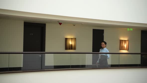Cheerful Female Walking on Balcony in Luxury Hotel alt