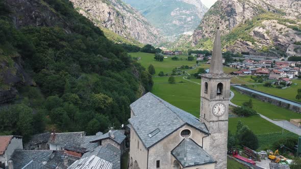 Aerial Sliding Down View of Medieval Town in Mountainous Valley in Summer