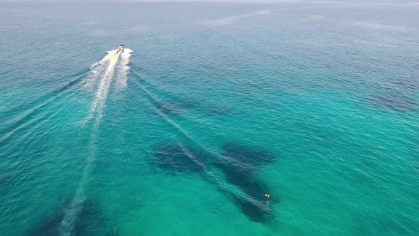 Aerial View of a Motor Boat Towing a Tube. Elounda, Crete, Greece