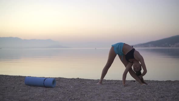 Beautiful Girl Doing a Warm-up By the Sea. Sports, Yoga, Sunrise.