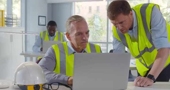 Two Male Architects Working on Laptop in Office alt