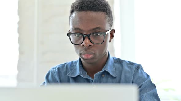 Portrait of Hardworking Young African Man Working on Laptop alt