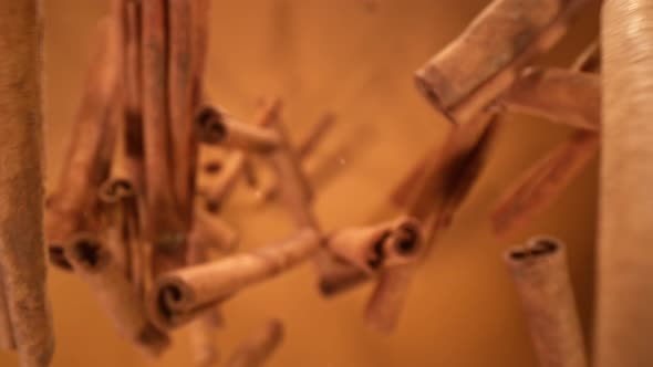 Super Slow Motion Shot of Cinnamonon Falling Down on Brown Gradient Background at 1000Fps alt