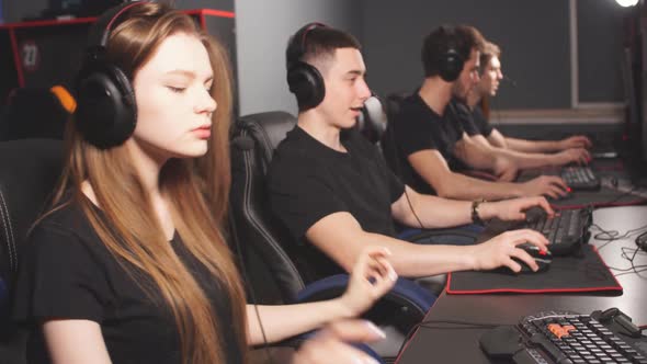 Woman in Team of eSport Gamers Playing Video Games on a Cyber Games Contest. alt