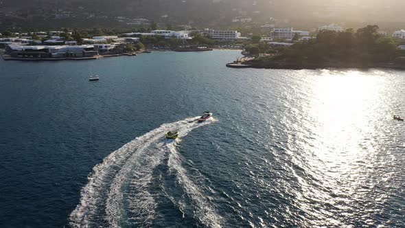 Aerial View of a Motor Boat Towing a Tube. Elounda, Crete, Greece