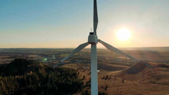 The Sun and a Wind Turbine Revolving in Its Background alt