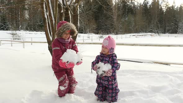 Lovely Kids Throwing A Handful Of Snow Up In The Air.