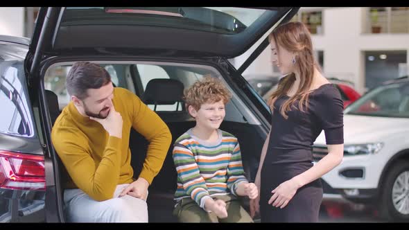 Portrait of Happy Caucasian Family in Car Dealership alt