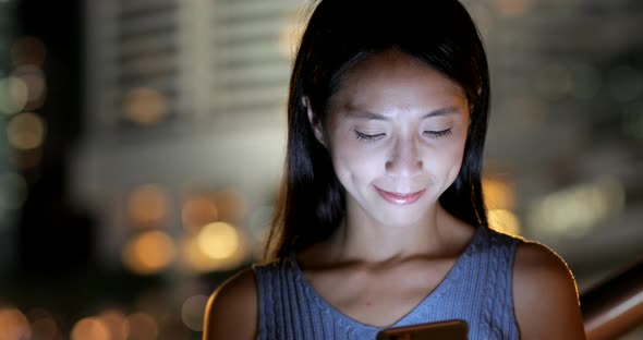 Woman use of smart phone at night  alt