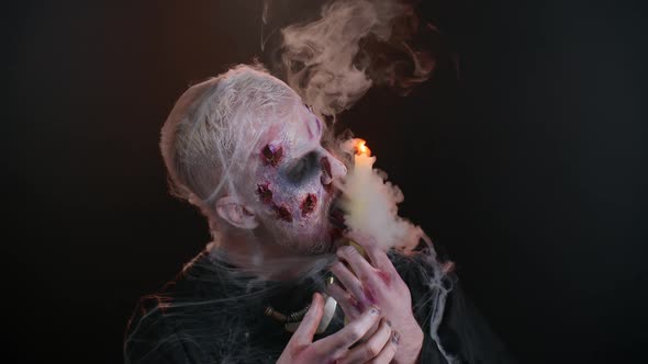 Frightening Man with Halloween Zombie Bloody Makeup Spells Conjures Over Candle Voodoo Rituals alt