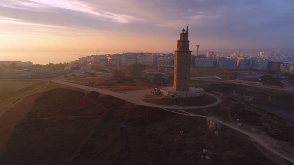 Ancient tower in city outskirts at sunset alt