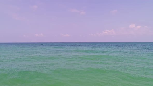 Drone backward tracking shot hovering above the sea waters and beach in Phuket Thailand alt