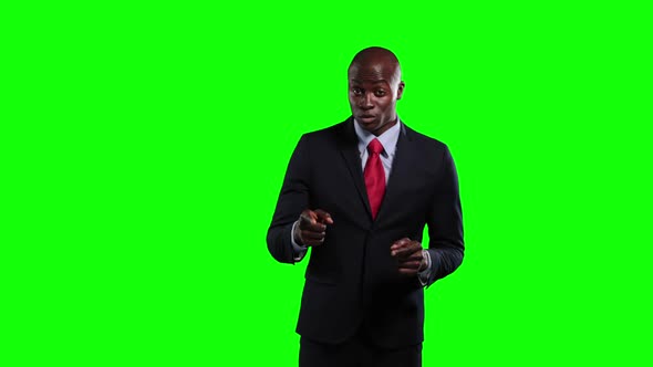 an African American man in suit talking in green background