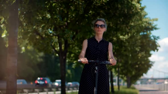 Eco Friendly Transport. Woman Drive Electric Scooter. Electric Urban Transportation. Kick Scooter. alt