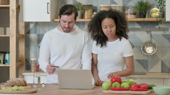 Mixed Race Couple Making Online Payment on Laptop alt
