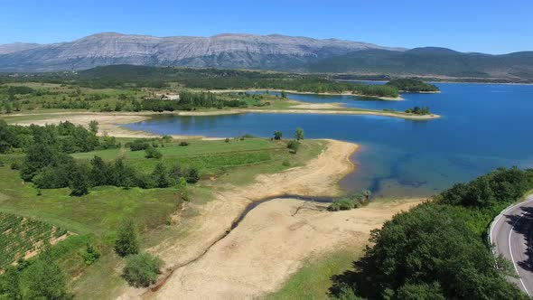 Flying above green environment of artificial lake Peruca, Croatia alt