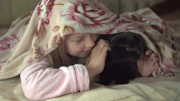 Little Schoolage Girl Hid Under Blanket with Her Cat