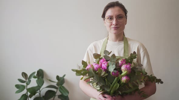 Portrait of a Professional Florist of a Young Woman in Glasses with a Bouquet of Bright Flowers