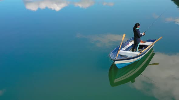 Woman on the Boat Catches a Fish on Spinning in Norway alt