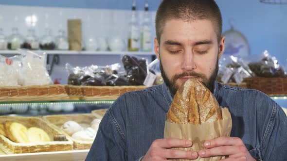 Close Up of a Cheerful Man Smelling Freshly Baked Bread