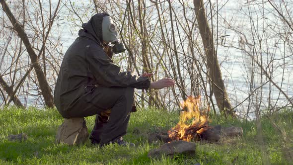 A Man in a Gas Mask Near a Fire alt