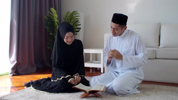 Handsome Muslim man teaching young woman read Quran 