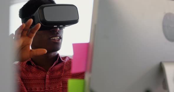 Front view of African American male graphic designer using virtual reality headset art desk in offic