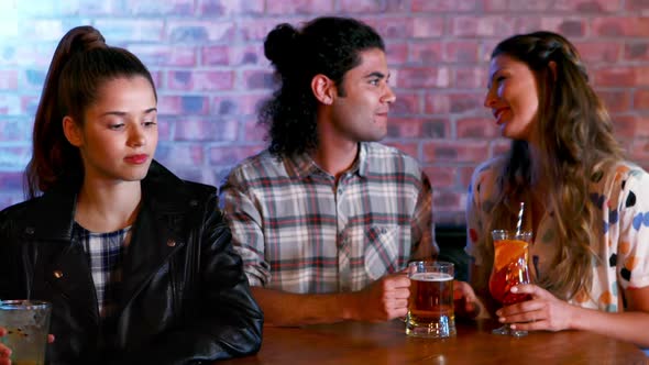 Jealous woman looking at couple flirting with each other alt