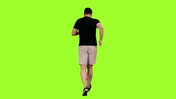 Rear View of a Man Jogging in Shorts and Black T-shirt