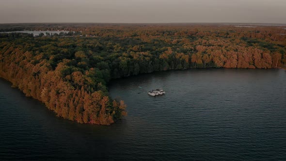 Cinematic aerial view from drone flying over boats floating on Mindemoya Lake, ON, Canada at dawn alt