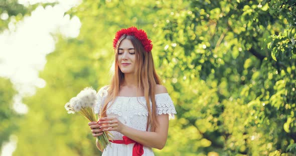 Beautiful Girl Blowing on Dandelions, Bouquet in Summer alt