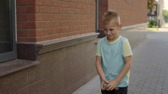 School Boy is Holding the Paper and Puts It to the Correct Bin for Paper alt