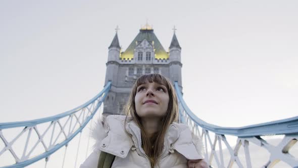 Tourist woman walking on Tower Bridge in London, England