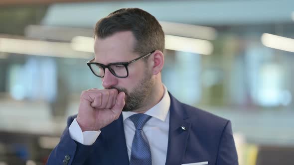 Portrait of Sick Middle Aged Businessman Coughing alt