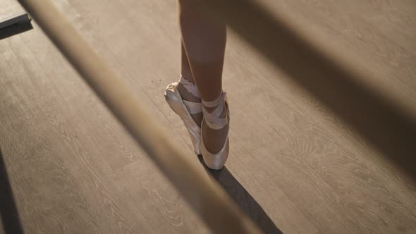 High Angle View of Slim Female Legs in Beige Pointes on Tiptoes Making Steps alt