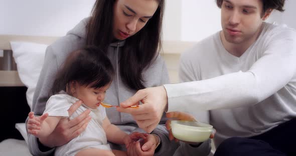Young Parents Give Healthy Food to Baby Baby's First Food