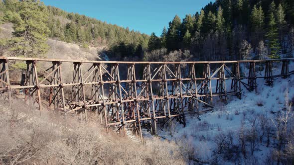 Drone view of an old wooden bridge with railroad tracks alt