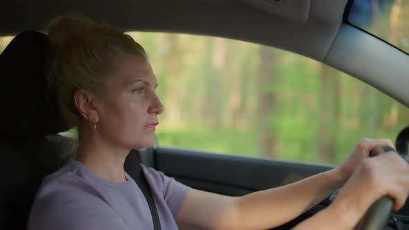 A Woman is Driving a Car alt