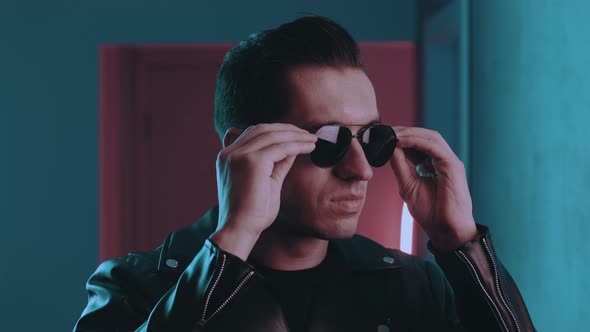 Portrait of Brutal Man Inside at Night Over Neon Lights of Nightclub. Serious Male Biker Put on alt