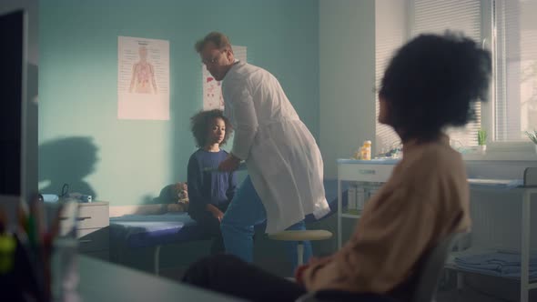 Man Doctor Giving Medical Advice African Mother After Examining Teen Daughter alt
